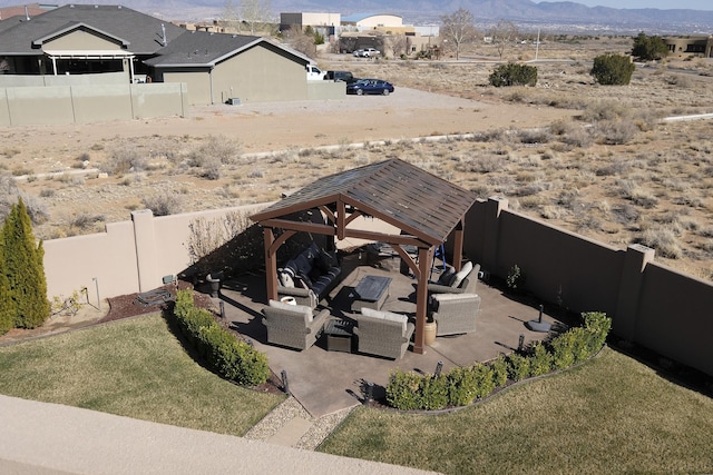 view of yard with an outdoor living space, a fenced backyard, a gazebo, a mountain view, and a patio area