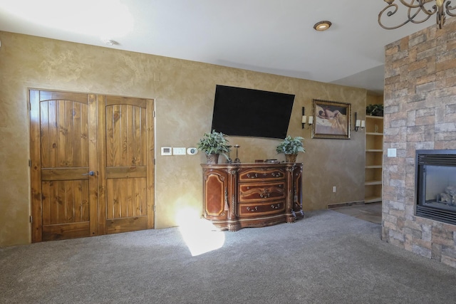 unfurnished living room featuring visible vents, carpet floors, and a stone fireplace