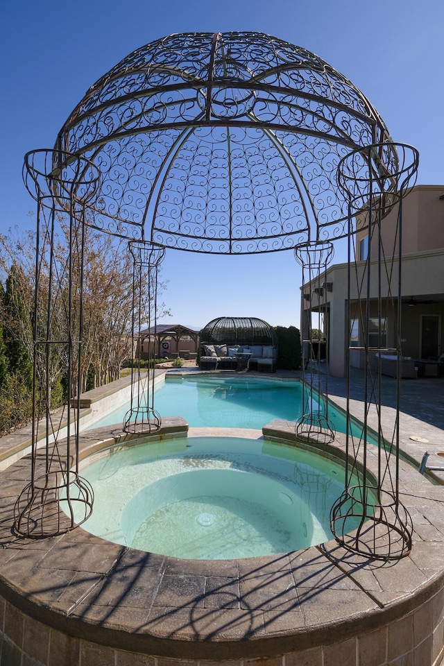 view of swimming pool with a patio area and a pool with connected hot tub