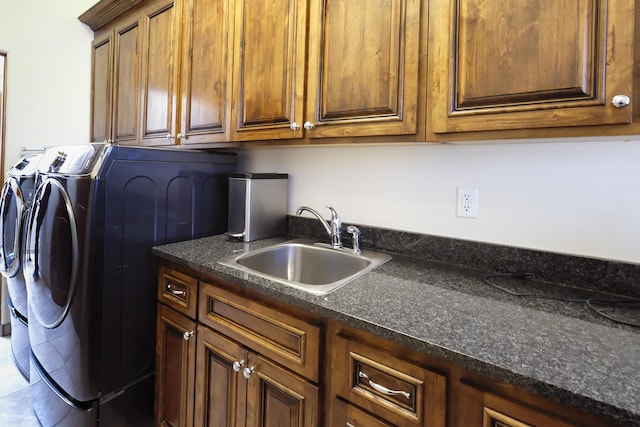 washroom with washing machine and dryer, cabinet space, and a sink