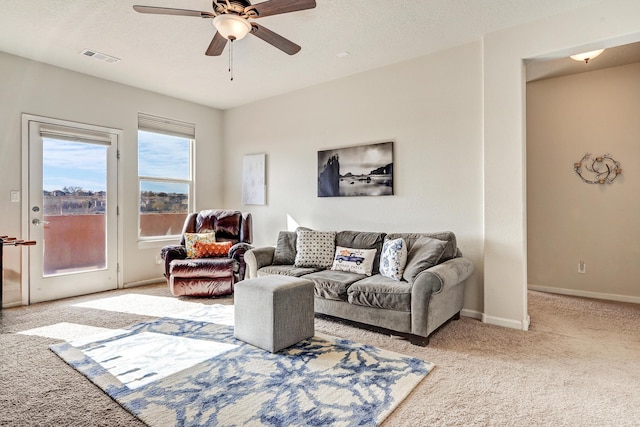 living area with carpet, visible vents, a ceiling fan, baseboards, and a textured ceiling