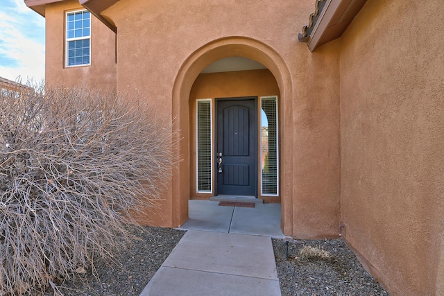 entrance to property featuring stucco siding