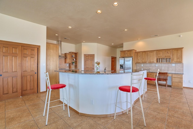 kitchen with open shelves, backsplash, a breakfast bar, and stainless steel fridge with ice dispenser