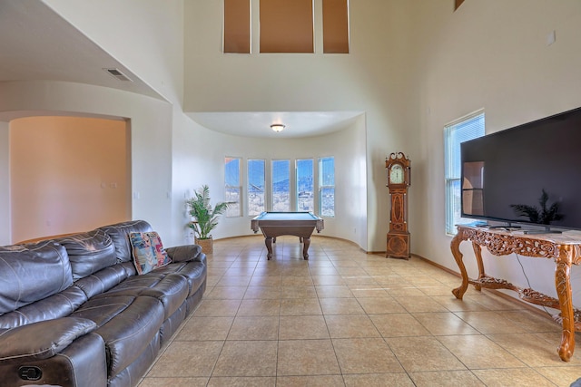 living area featuring light tile patterned flooring, visible vents, billiards, and a high ceiling