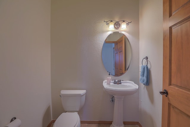 bathroom with toilet and baseboards