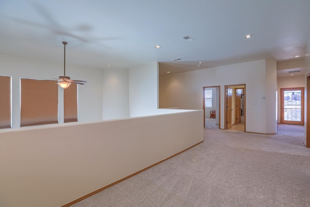 empty room featuring recessed lighting, light colored carpet, and baseboards