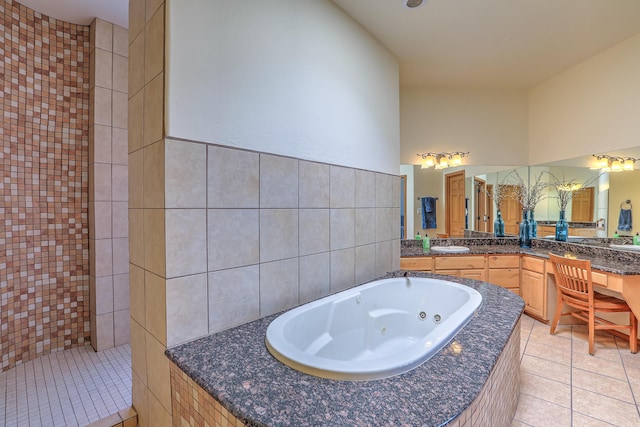 full bath featuring vanity, tile patterned floors, a jetted tub, and tile walls