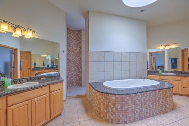 full bath featuring tile patterned floors, a bath, walk in shower, and a sink