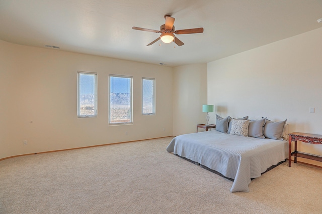 bedroom with visible vents, baseboards, light colored carpet, and a ceiling fan