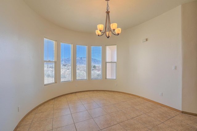 unfurnished room with light tile patterned floors, a notable chandelier, and baseboards