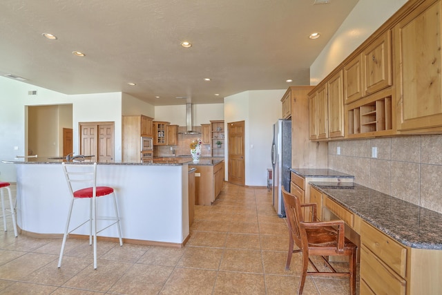 kitchen featuring built in study area, wall chimney range hood, a breakfast bar area, stainless steel appliances, and open shelves