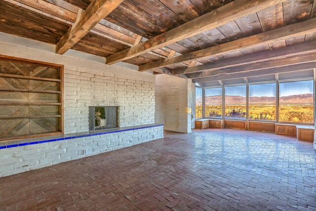 3805 Riverview Rd NW, Albuquerque, NM 87105 - unfurnished living room featuring a wooden ceiling with exposed beams, a mountain view, and a fireplace