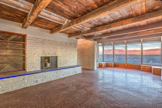 3805 Riverview Rd NW, Albuquerque, NM 87105 - unfurnished living room featuring a wood ceiling with exposed beams, a fireplace, and brick flooring