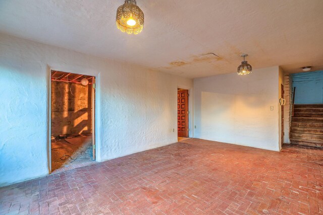 3805 Riverview Rd NW, Albuquerque, NM 87105 - spare room featuring brick patterned floors and stairway