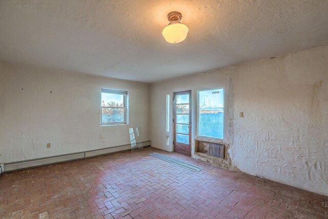 3805 Riverview Rd NW, Albuquerque, NM 87105 - unfurnished room with a baseboard radiator, brick flooring, a fireplace, and a textured ceiling
