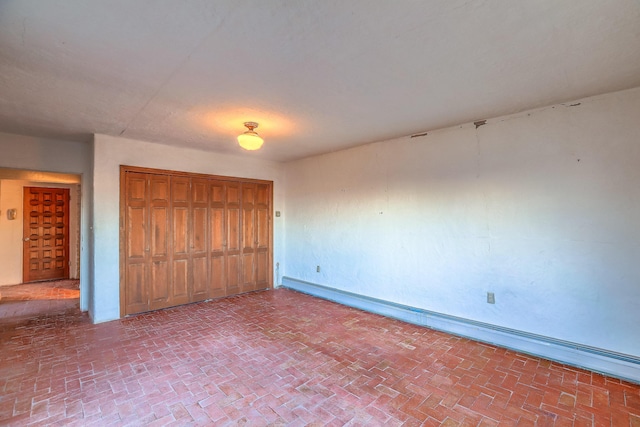3805 Riverview Rd NW, Albuquerque, NM 87105 - unfurnished bedroom featuring brick patterned floors, a baseboard radiator, and a closet