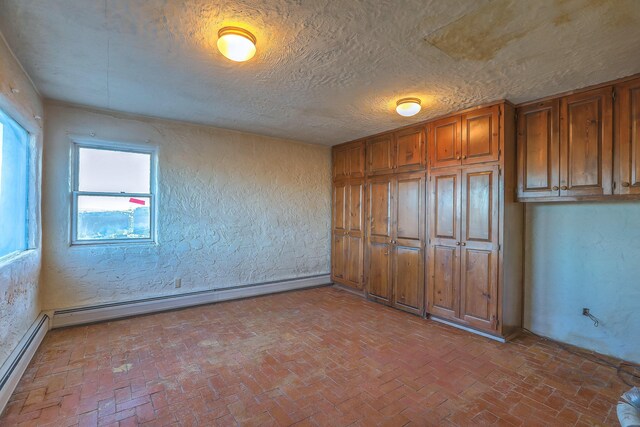 3805 Riverview Rd NW, Albuquerque, NM 87105 - unfurnished bedroom with brick floors, a baseboard radiator, a textured wall, and a textured ceiling