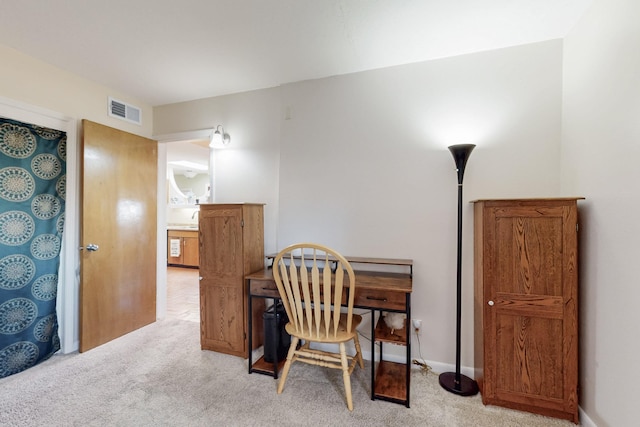 office space with a sink, visible vents, carpet floors, and baseboards