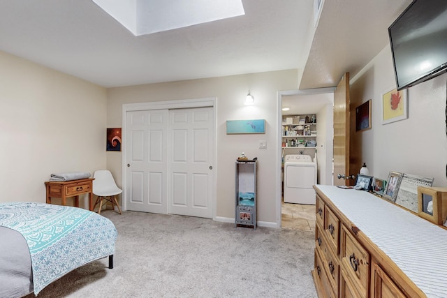 bedroom with baseboards, a closet, light carpet, and washer / dryer