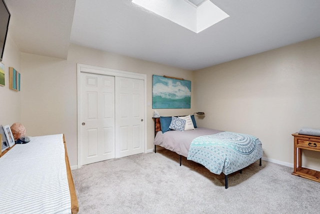 carpeted bedroom with a closet, baseboards, and a skylight