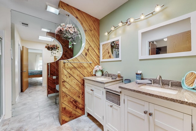 bathroom featuring double vanity, visible vents, and a sink