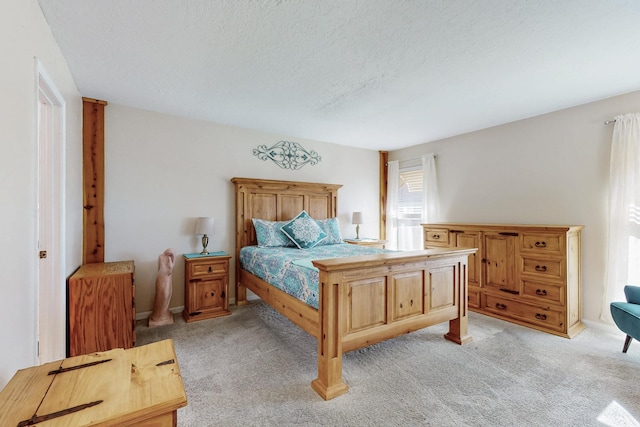 bedroom with light colored carpet and a textured ceiling