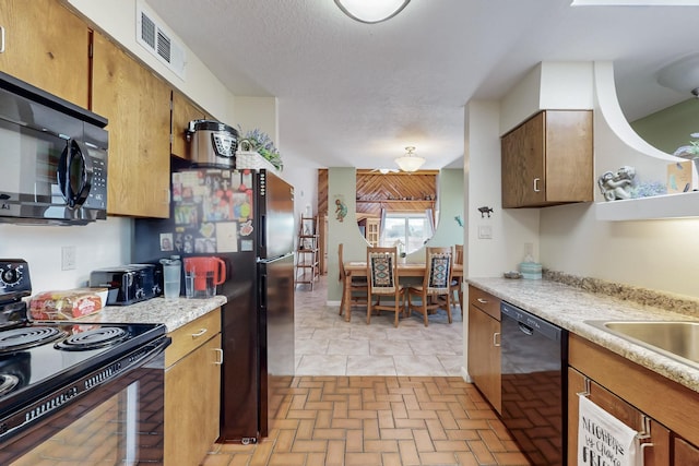 kitchen with visible vents, black appliances, brown cabinetry, light countertops, and brick floor