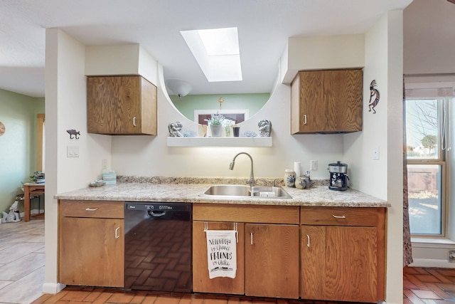 kitchen featuring light countertops, black dishwasher, brown cabinets, a skylight, and a sink