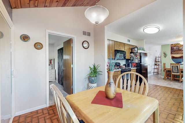 dining room featuring brick floor, visible vents, and baseboards