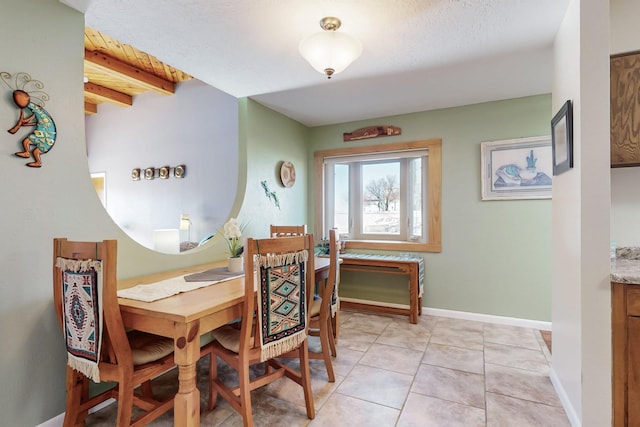 dining space featuring light tile patterned floors and baseboards