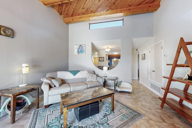 living room featuring baseboards, visible vents, light tile patterned flooring, wooden ceiling, and beamed ceiling