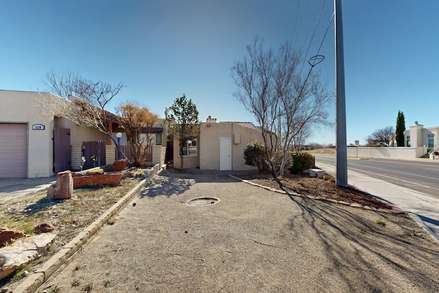 view of front facade with stucco siding and fence