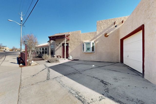 exterior space featuring stucco siding, driveway, and a garage