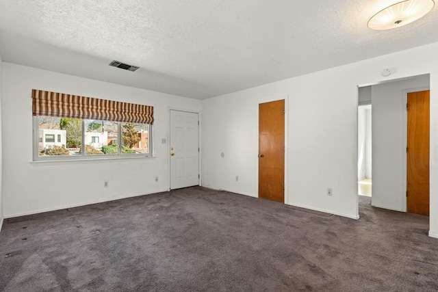 empty room with visible vents, carpet floors, and a textured ceiling