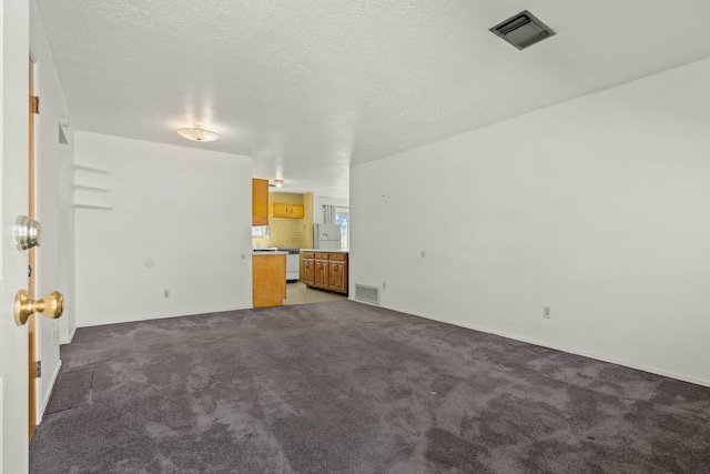 unfurnished living room featuring visible vents, a textured ceiling, and carpet