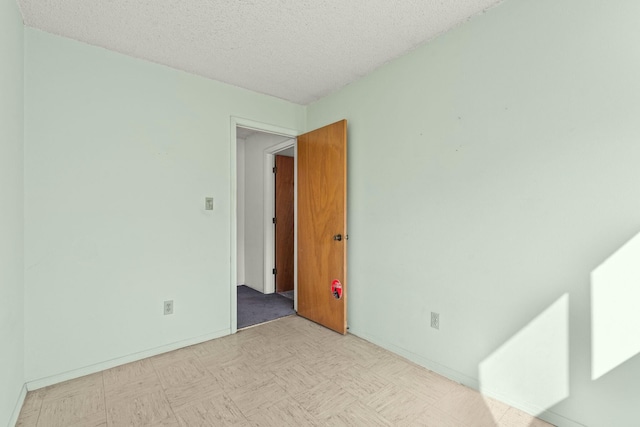 empty room featuring light floors and a textured ceiling