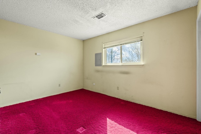 spare room featuring electric panel, visible vents, a textured ceiling, and carpet floors