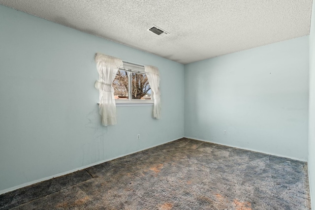 unfurnished room featuring visible vents, baseboards, carpet, and a textured ceiling