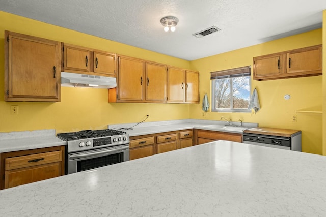 kitchen featuring visible vents, under cabinet range hood, a sink, white dishwasher, and gas range