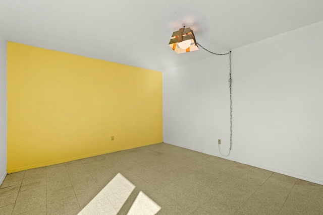 unfurnished room featuring tile patterned floors and baseboards