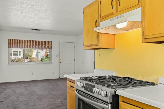 kitchen featuring gas stove, visible vents, light countertops, under cabinet range hood, and dark colored carpet