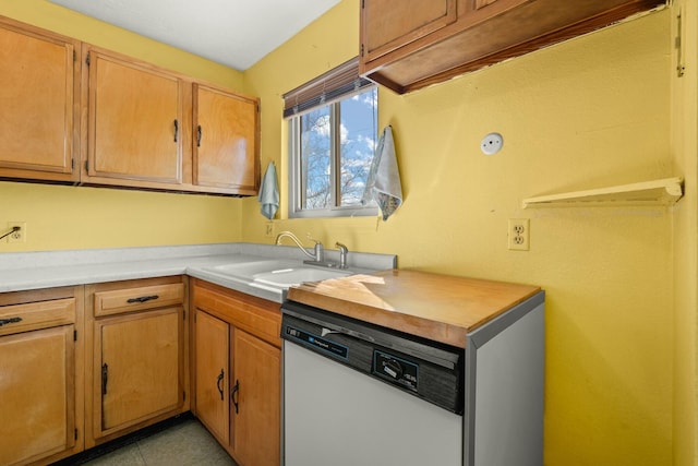 kitchen with dishwasher, light countertops, light tile patterned flooring, and a sink