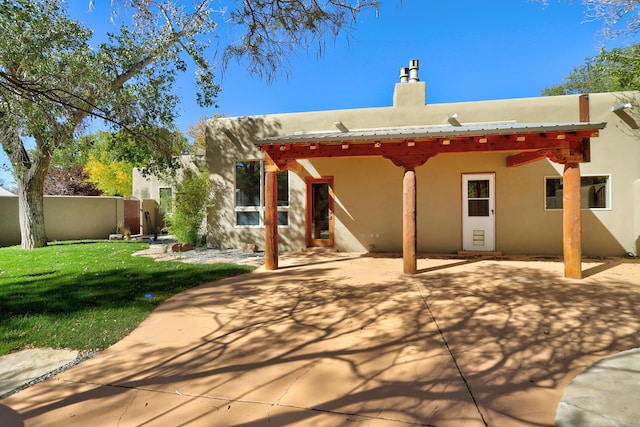 back of house featuring a yard, stucco siding, a patio, and fence