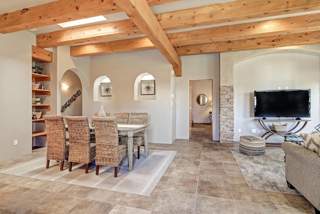 dining space with beam ceiling