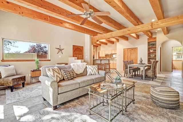 living area with beam ceiling, recessed lighting, arched walkways, and ceiling fan