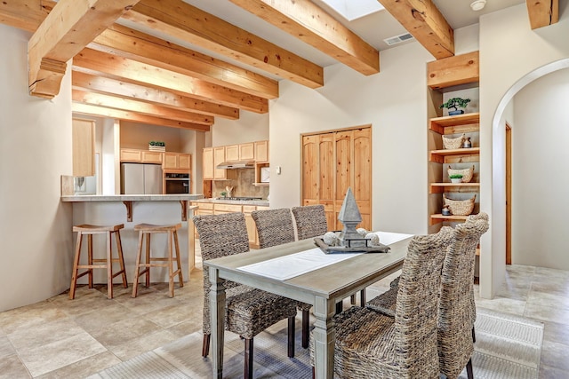 dining room featuring visible vents, arched walkways, and beamed ceiling