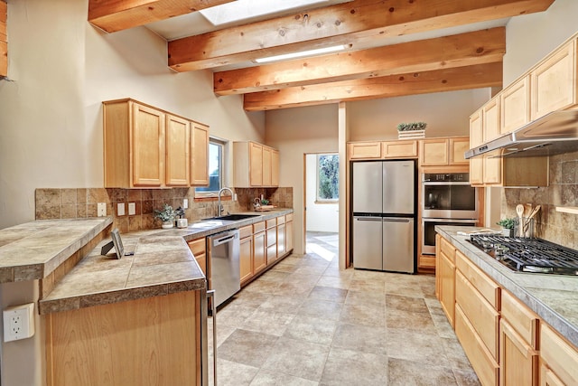 kitchen with light brown cabinetry, beamed ceiling, backsplash, and appliances with stainless steel finishes