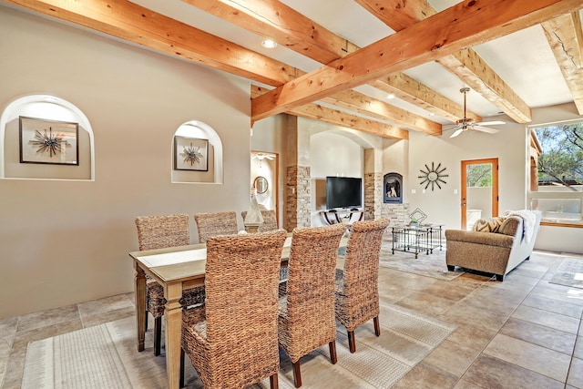 dining space with beam ceiling and a ceiling fan