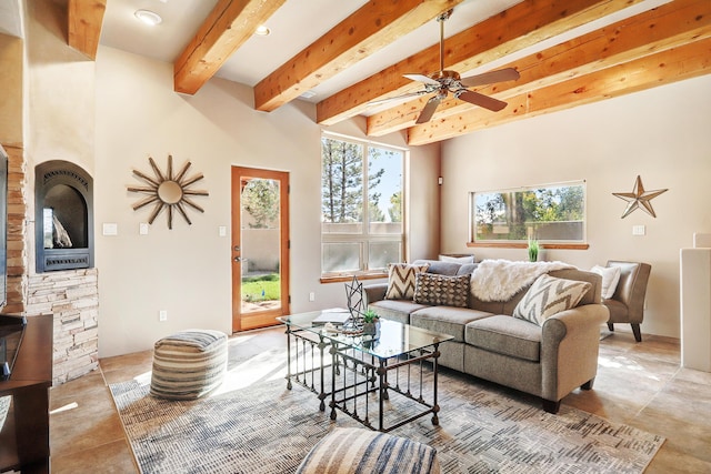 living room with beamed ceiling, a wood stove, and a ceiling fan