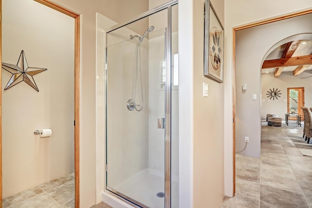 bathroom featuring beam ceiling, tile patterned floors, and a shower stall